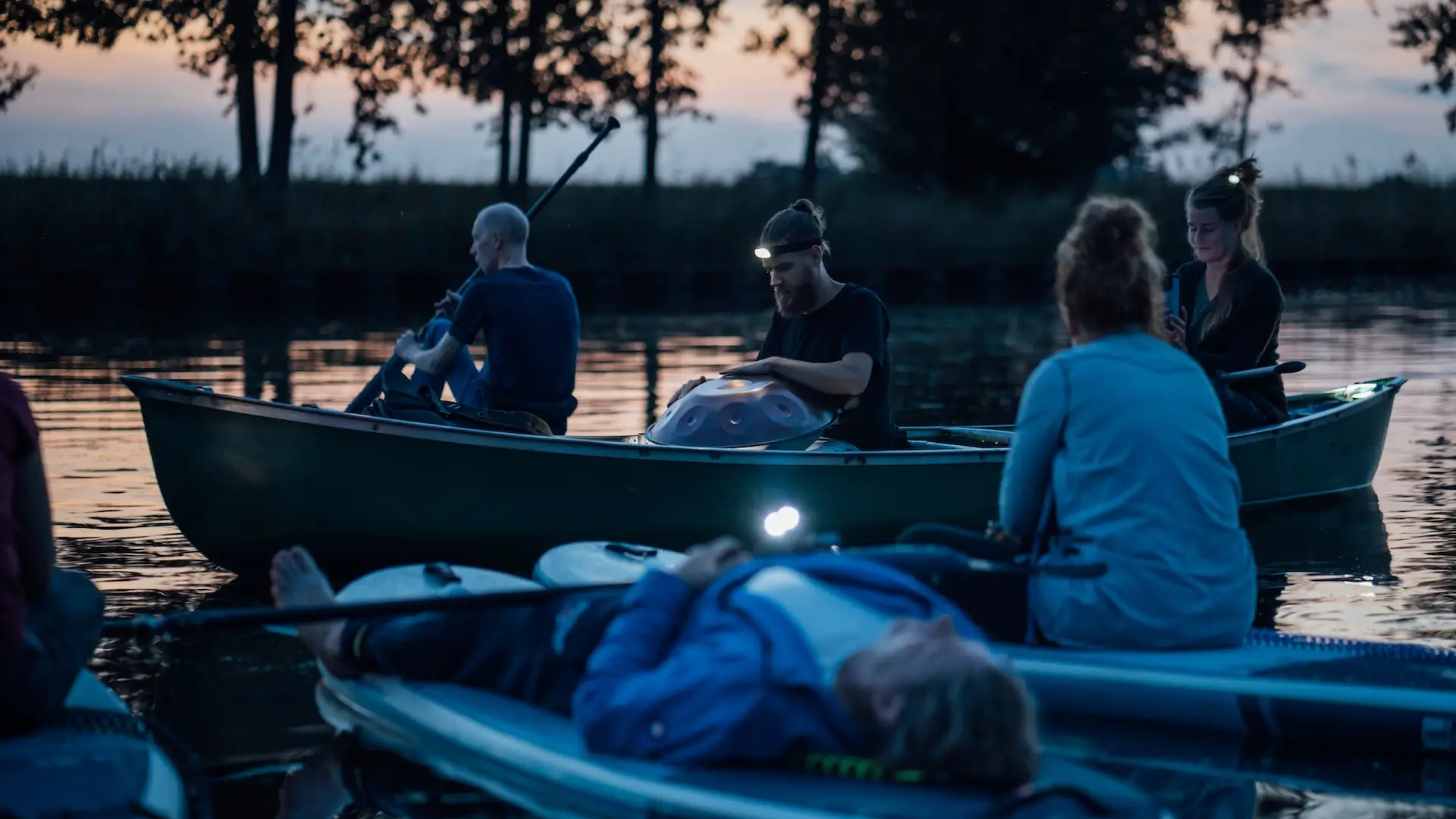 Handpan op het water. Ralf Silvius met Caroline Schmitt en Eemsuppen. Ralf speelt Handpan in een kano tijdens het jaarlijkse event op het water, waar deelnemers meedoen op de sup / standup paddle board